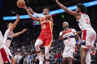Kyshawn George (2e depuis la gauche) et les Wizards ont su défendre à la perfection face à Trae Young (11) pour une première victoire cette saison. KEYSTONE/AP/John Bazemore